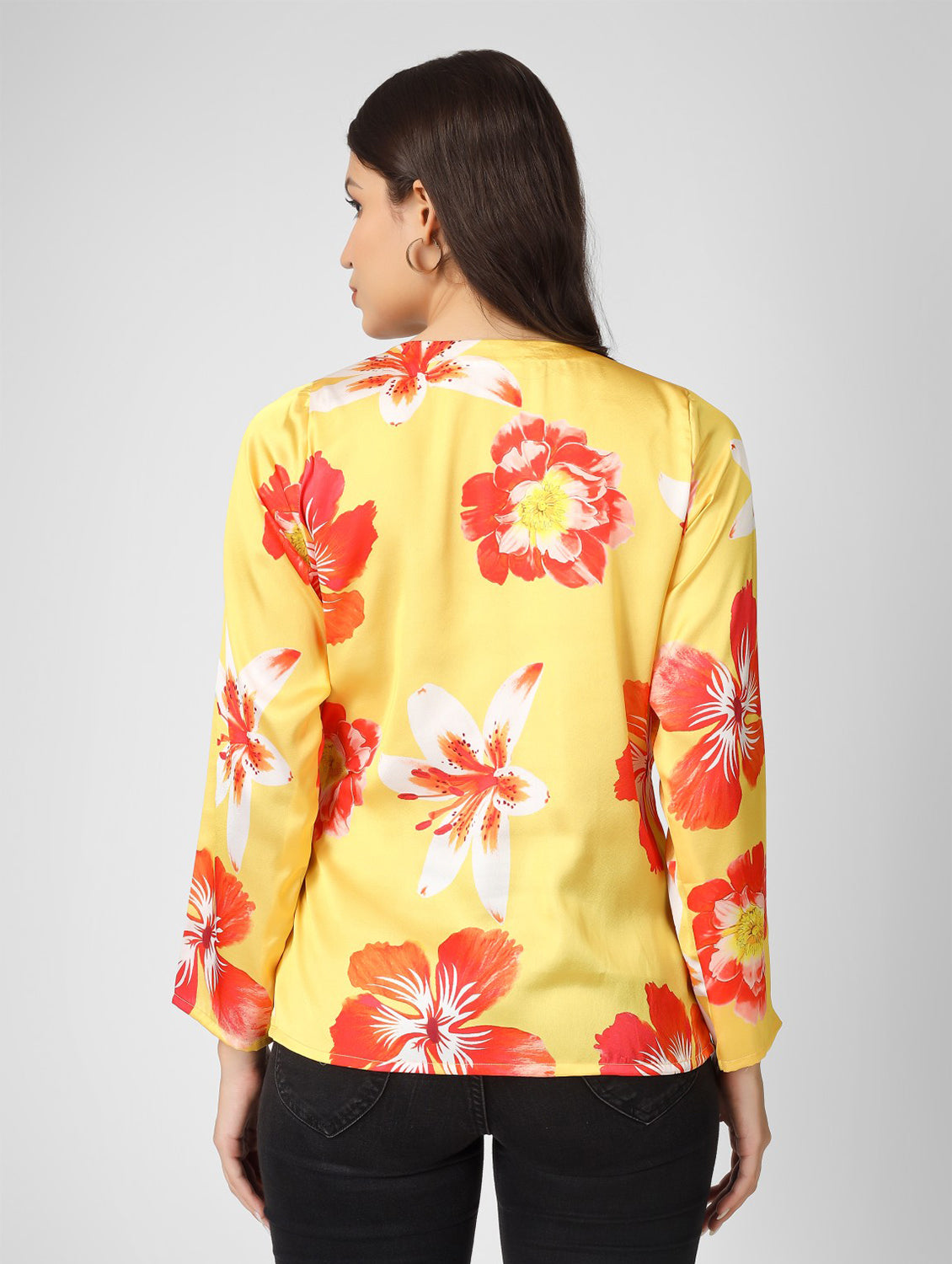 Bright and stylish, this printed yellow satin top features a chic overlap design with full sleeves and a trendy tie-knot detail.