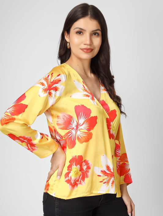 Bright and stylish, this printed yellow satin top features a chic overlap design with full sleeves and a trendy tie-knot detail.