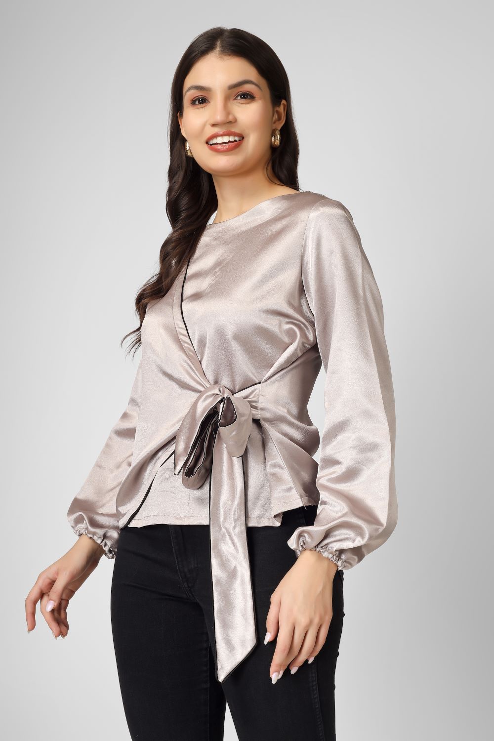Elevate your look with this plain overlap satin top featuring full sleeves, a stylish tie knot, and neat piping detailing.