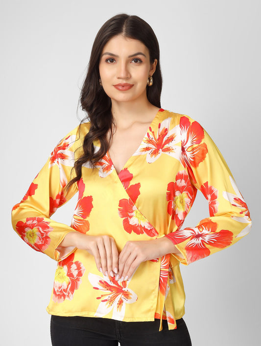 Bright and stylish, this printed yellow satin top features a chic overlap design with full sleeves and a trendy tie-knot detail.